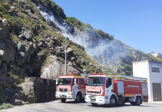 Incendio forestal na ladeira dun monte detrás da depuradora no porto de Malpica de Bergantiños